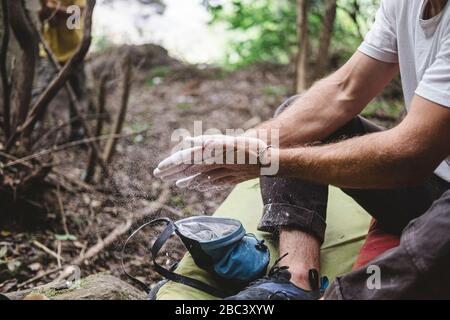 Primo piano delle mani dell'arrampicatore di roccia che si aggrafano le mani con il gesso Foto Stock