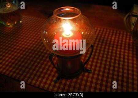 Candela rossa da tavolo su un panno a strisce Foto Stock