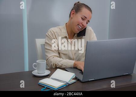 Lavoro amministrativo femminile in ufficio e risposta al telefono Foto Stock