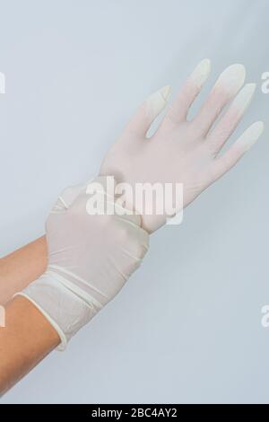 Mani da donna che indossano guanti in lattice Foto Stock
