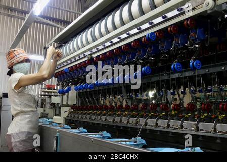 Donna che lavora su una macchina in una fabbrica di seta a da Lat, Vietnam Foto Stock