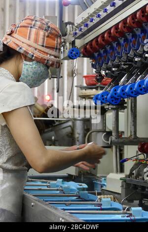 Donna che lavora su una macchina in una fabbrica di seta a da Lat, Vietnam Foto Stock