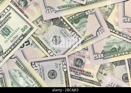 Molte banconote da cinquanta dollari statunitensi su una superficie piana di fondo vicina. Vista dall'alto a disposizione piatta. Successo astratto o concetto di business Foto Stock