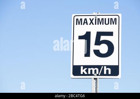 Segnale di avvertimento velocità 15 KM/H isolato con sfondo blu. Foto Stock