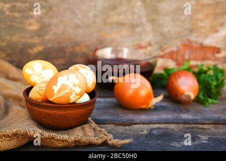 Le uova di pasqua con pattern colorati con buccia di cipolla sul vecchio sfondo di legno. Foto Stock