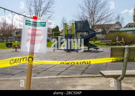 Un cartello di attenzione COVID-19 chiuso per il parco giochi, apposta su una panchina con un plaground sullo sfondo Foto Stock