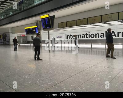 Gli arrivi vuoti si concourse al Terminal 5 dell'aeroporto di Heathrow, Londra, mentre le persone aspettano l'arrivo di un volo in arrivo da Sydney via Singapore, mentre il Regno Unito continua a bloccarsi per contribuire a frenare la diffusione del coronavirus. Foto Stock