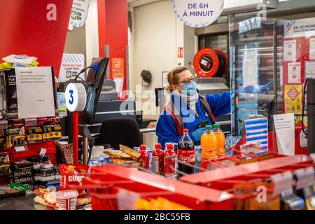 (200403) -- PARIGI, 3 aprile 2020 (Xinhua) -- UN cassiere che indossa una maschera protettiva serve i clienti dietro un piatto in plexiglass in un supermercato a Parigi, Francia, 2 aprile 2020. Gli ospedali francesi hanno registrato una perdita di un giorno di 471 pazienti affetti da coronavirus, portando il totale a 4.503, mentre circa 900 anziani dipendenti che vivono nelle case di cura erano morti del virus dall'inizio dell'epidemia, un funzionario sanitario ha detto giovedì. In totale, 59,105 persone avevano provato positivo per il virus, fino a 2.116 in un giorno, contro un aumento di 4.861 il Mercoledì, ha detto direttore generale della Salute Jerome Salomon a Foto Stock