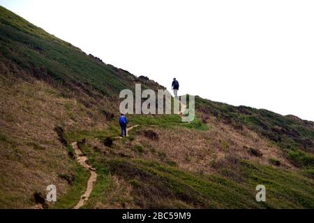 Un paio di escursionisti a piedi lungo il percorso dalla Tidna Shute Valley fino a Sharpnose Point più alto sul South West Coastal Path, North Cornwall, Inghilterra. Foto Stock
