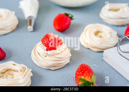 Fragola PavlovaHomemade piccola fragola pavlova meringa torte alla crema dessert con menta fresca Foto Stock