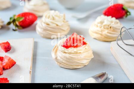 Fragola PavlovaHomemade piccola fragola pavlova meringa torte alla crema dessert con menta fresca Foto Stock