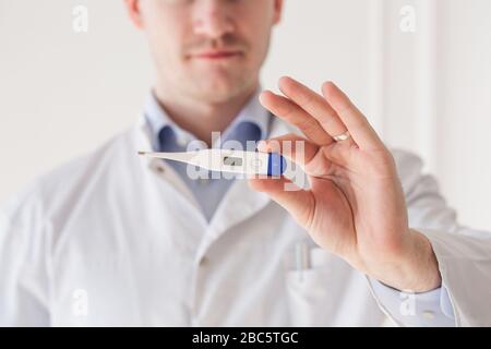 Primo piano del medico maschile con il termometro Foto Stock