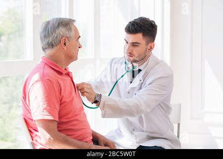 Uomo anziano che è esaminato da un medico Foto Stock