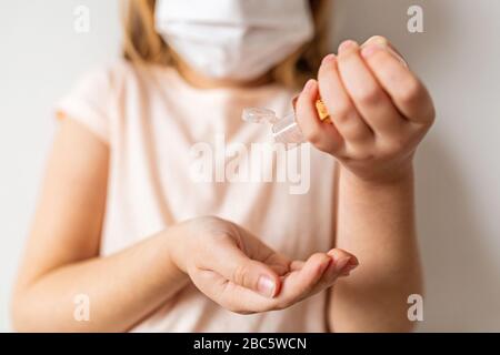 Bambina caucasica che usa gel igienizzante per le mani per l'igiene delle mani pulite prevenzione dell'epidemia di virus del coronavirus. Mantenere le mani pulite durante Foto Stock