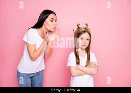 Foto di affascinante mummia overjoyed che soffia bacini poco arrabbiato figlia viziata con corona sulla testa vanto persona indossare casual t-shirt jeans isolati Foto Stock