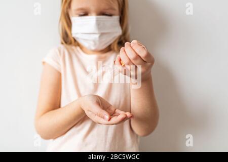 Bambina caucasica che usa gel igienizzante per le mani per l'igiene delle mani pulite prevenzione dell'epidemia di virus del coronavirus. Mantenere le mani pulite durante Foto Stock