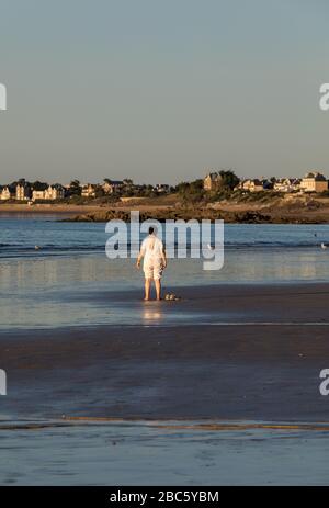 Saint Malo, Francia - 16 Settembre 2018: una donna a praticare yoga sulla spiaggia di Saint Malo nel bagliore del sole al tramonto. Brittany, Francia Foto Stock