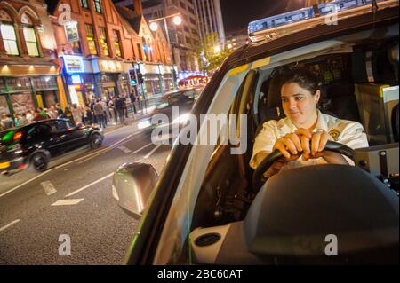Giovane donna Paramedic in attesa nella sua emergenza veircle Birmingham City Centre su un occupato Sabato notte. Foto Stock