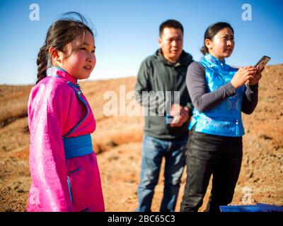 (200403) -- ALXA, 3 aprile 2020 (Xinhua) -- CE Geng(L) si prepara a prendere una classe online come i suoi genitori stanno in Alxa sinistra Banner, regione Autonoma Mongolia interna della Cina del nord, 1 aprile 2020. CE Geng, un quarto Grader di 9 anni di una scuola mongolo in Alxa Banner sinistra, si è spostato qui con i suoi genitori a guardare le pecore come il pastore che avevano assunto da altra provincia non è tornato a causa del focolaio di COVID-19. Il ranch della famiglia si trova vicino al confine tra la Cina e la Mongolia nella parte settentrionale di Alxa, a più di 6 ore di auto dal centro di Alxa Left Banner. Il roccioso Foto Stock