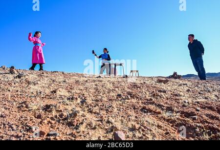 (200403) -- ALXA, 3 aprile 2020 (Xinhua) -- il Geng CE (L) pratica la danza mongola durante la pausa di classe in banner sinistro Alxa, regione Autonoma Mongolia interna della Cina settentrionale, 1 aprile 2020. CE Geng, un quarto Grader di 9 anni di una scuola mongolo in Alxa Banner sinistra, si è spostato qui con i suoi genitori a guardare le pecore come il pastore che avevano assunto da altra provincia non è tornato a causa del focolaio di COVID-19. Il ranch della famiglia si trova vicino al confine tra la Cina e la Mongolia nella parte settentrionale di Alxa, a più di 6 ore di auto dal centro di Alxa Left Banner. Il roccioso gobi monte Foto Stock