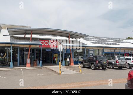 Auto parcheggiate fuori da un supermercato rurale Coles in un edificio con pannelli solari multipli sulla costa medio-settentrionale del nuovo Galles del Sud in Australia Foto Stock
