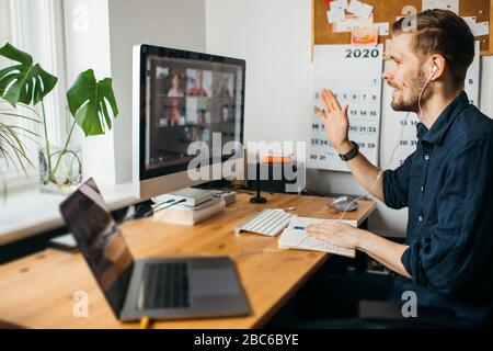 Giovane che ha videochiamare via computer in casa. Soggiorno a casa e lavoro da casa concetto durante la pandemia di Coronavirus. Foto Stock