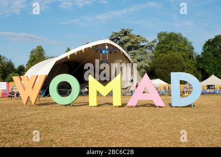 Cartello WOMAD multicolore (World of Music and Dance) presso il sito del festival, tenda Charlie Gillett, Charlton Park, Regno Unito. Luglio 28, 2019 Foto Stock