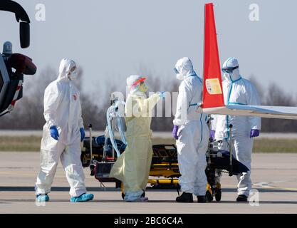 02 aprile 2020, Sassonia, Dresda: Il personale medico è sul tarmac all'aeroporto internazionale di Dresda durante l'arrivo di un aereo di ambulanza con un malato grave Covid 19 paziente dalla Francia. L'aereo Learjet 45 proveniva da Metz e atterrò all'aeroporto di Dresda nel pomeriggio. Come annunciato su richiesta dal Dresden University Hospital, altri due pazienti francesi dovrebbero arrivare in serata. L'ospedale specialistico Coswig, l'ospedale Dresden-Friedrichstadt e l'ospedale universitario locale si prenderebbero cura di uno dei pazienti. Nulla è stato rivelato sulla loro identità. La Sassonia aveva già un annuncio Foto Stock