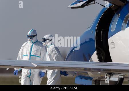 02 aprile 2020, Sassonia, Dresda: I membri dell'equipaggio si trovano di fronte a un aereo di ambulanza all'aeroporto internazionale di Dresda dopo aver caricato un paziente Covid 19 gravemente malato dalla Francia. L'aereo Learjet 45 proveniva da Metz e atterrò all'aeroporto di Dresda nel pomeriggio. Come annunciato su richiesta dal Dresden University Hospital, altri due pazienti francesi dovrebbero arrivare in serata. L'ospedale specialistico Coswig, l'ospedale Dresden-Friedrichstadt e l'ospedale universitario locale si prenderebbero cura di uno dei pazienti. Nulla è stato rivelato sulla loro identità. La Sassonia aveva già ammesso Foto Stock