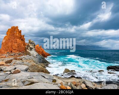 La silhouette del famoso reef porfiritico conosciuto come "rocce rosse" da Arbatax, Ogliastra, Capo Bellavista, Sardegna, Italia Foto Stock