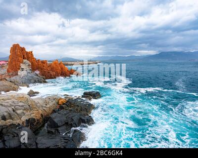 La silhouette del famoso reef porfiritico conosciuto come "rocce rosse" da Arbatax, Ogliastra, Capo Bellavista, Sardegna, Italia Foto Stock