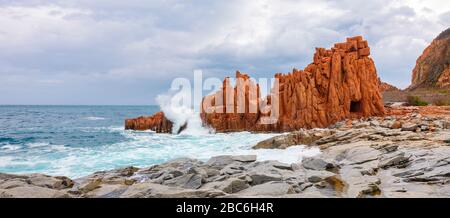 La silhouette del famoso reef porfiritico conosciuto come "rocce rosse" da Arbatax, Ogliastra, Capo Bellavista, Sardegna, Italia Foto Stock