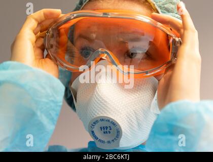 Dresda, Germania. 03rd Apr, 2020. ILLUSTRAZIONE - un tecnico dentale indossa occhiali protettivi e indossa un respiratore FFP3 (scena posta) prima di trattare un paziente corona in un ufficio dentale. Credito: Robert Michael/dpa-Zentralbild/dpa/Alamy Live News Foto Stock