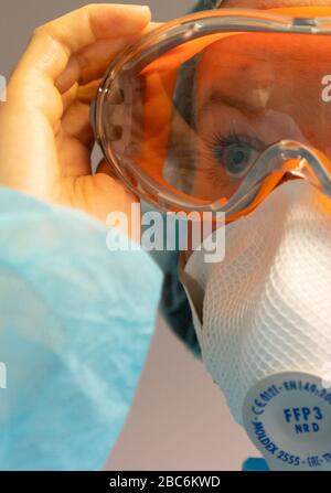 Dresda, Germania. 03rd Apr, 2020. ILLUSTRAZIONE - UN assistente dentale indossa occhiali protettivi e indossa un respiratore FFP3 (scena posta) prima di trattare un paziente corona in un ufficio dentale. Credito: Robert Michael/dpa-Zentralbild/dpa/Alamy Live News Foto Stock