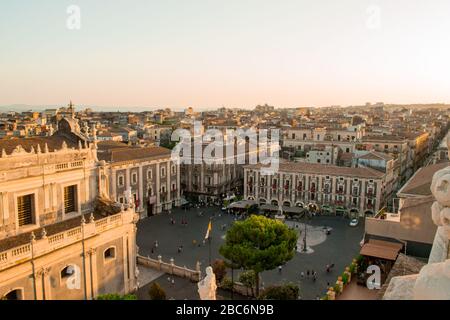 Catania, Sicilia in Italia. Vista aerea dei tetti della città e in particolare della magnifica piazza del Duomo al tramonto, colori caldi e luce soffusa. Foto Stock