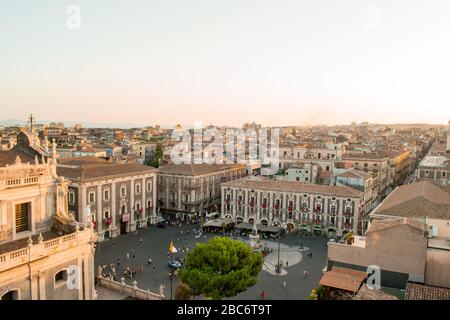 Catania, Sicilia in Italia. Vista aerea dei tetti della città e in particolare della magnifica piazza del Duomo al tramonto, colori caldi e luce soffusa. Foto Stock