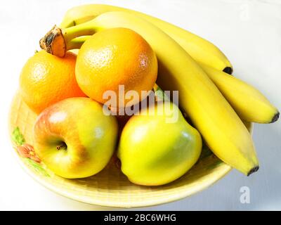 Ciotola di frutta con mele braeburn arance e banane su una tovaglia bianca Foto Stock