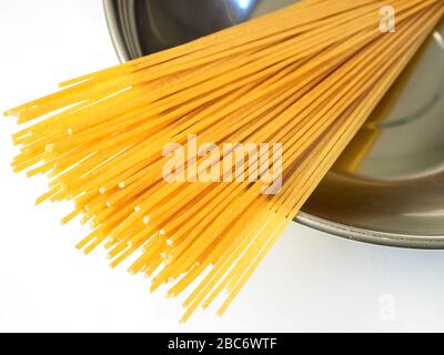 100 grammi di spaghetti di grano integrale in una ciotola di acciaio inossidabile su una tovaglia bianca Foto Stock