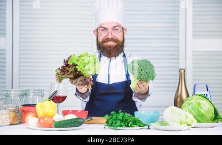 Chef professionista con bearded che cucinano cibo sano. Ricetta vegetariana sana. Scelgo solo ingredienti sani. Uomo cuoco cappello e grembiule tenere broccoli. Verdure biologiche. Concetto di nutrizione sana. Foto Stock