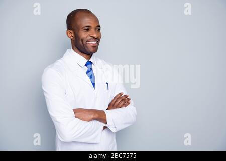 Foto di allegro medico pelle scura ragazzo virologo agente corona virus seminario ascoltare colleghi ricerca braccia incrociate indossare bianco camice da laboratorio Foto Stock