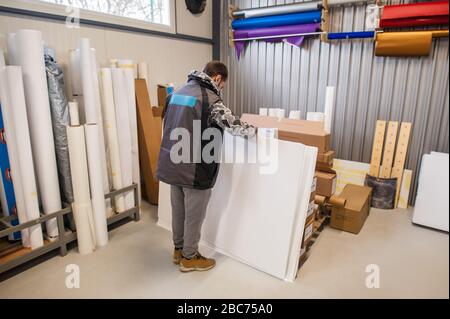 L'operatore del tecnico addetto alla stampa lavora in una grande sala stampa digitale e in un ufficio di stampa con molti tipi diversi di macchina Foto Stock