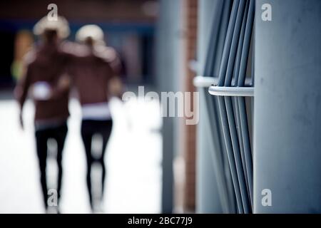 Colpo di una recinzione di metallo con gente che cammina fuori Foto Stock