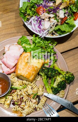 Immagine dall'alto del piatto di verdure e del piatto di insalate. Cibo sano di dieta su una tavola di legno. Foto Stock