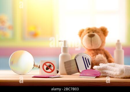 Trattamento e prevenzione del pidocchi con attrezzatura su tavolo in legno nella stanza colorata per bambini. Composizione orizzontale. Vista frontale Foto Stock