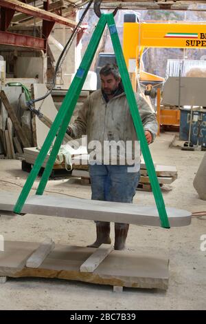 Covid 19 - Stonemason Justin Warren prepara un headstone, uno di un numero quotidiano crescente (9 quel giorno) che è ordinato dalla cava di pietra di Purbeck a Foto Stock