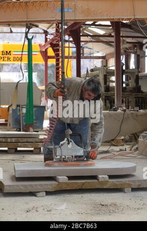 Covid 19 - Stonemason Justin Warren prepara un headstone, uno di un numero quotidiano crescente (9 quel giorno) che è ordinato dalla cava di pietra di Purbeck a Foto Stock