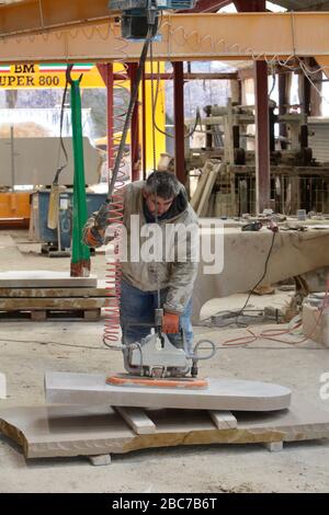 Covid 19 - Stonemason Justin Warren prepara un headstone, uno di un numero quotidiano crescente (9 quel giorno) che è ordinato dalla cava di pietra di Purbeck a Foto Stock