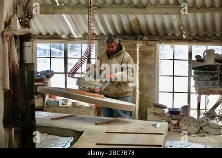 Covid 19 - Stonemason Justin Warren prepara un headstone, uno di un numero quotidiano crescente (9 quel giorno) che è ordinato dalla cava di pietra di Purbeck a Foto Stock