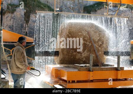 Covid 19 - Stonemason Justin Warren taglia una lastra di pietra di purbeck recentemente quarried in preparazione per la generazione dei molti nuovi headstones richiesti come contro Foto Stock