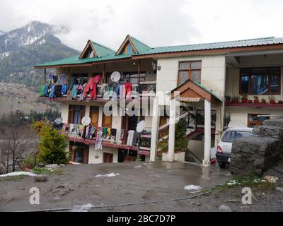 Manali, Himachal Pradesh, India - Marzo 2018: Edificio residenziale con vestiti appesi fuori nei balconi per asciugarsi. Foto Stock